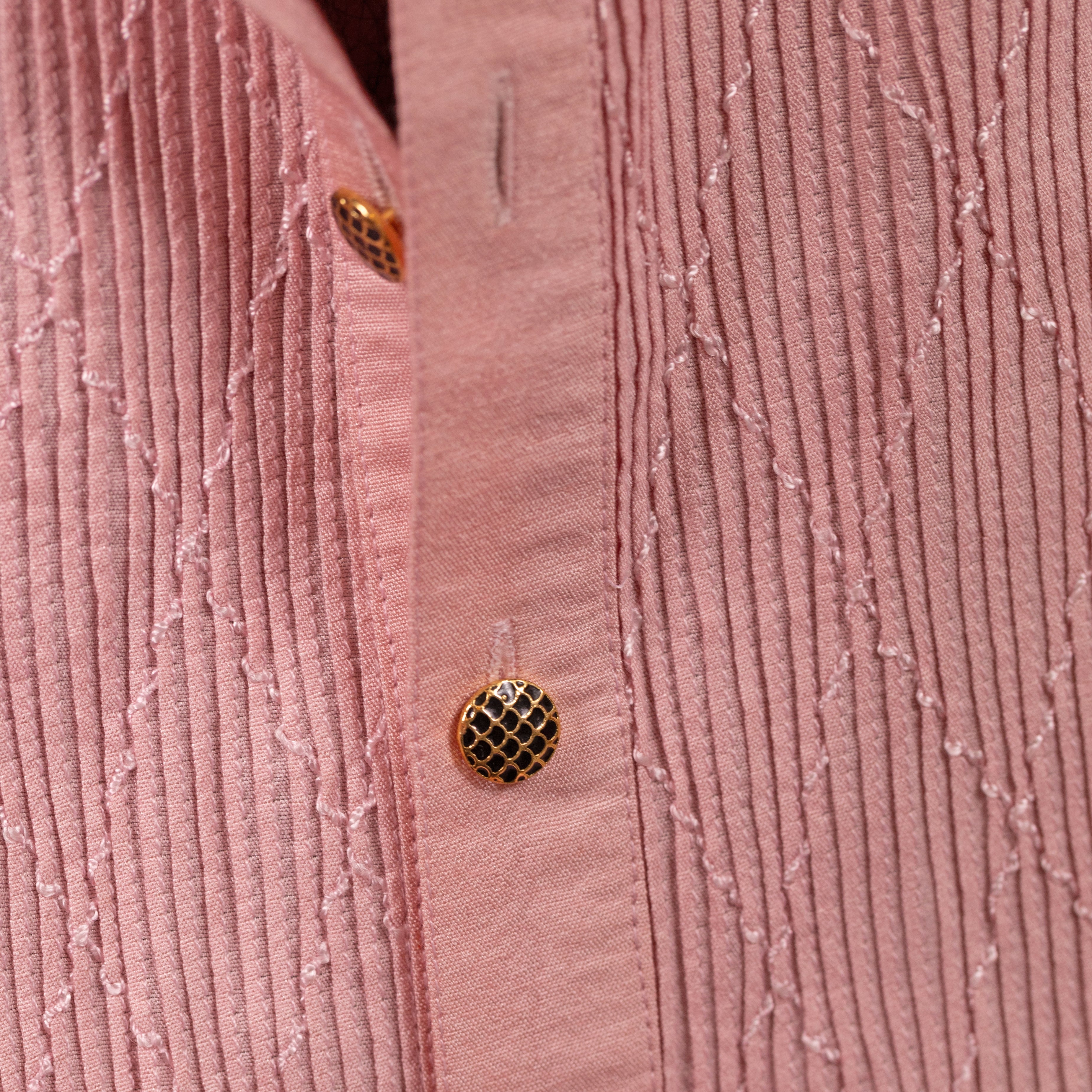 Close-up of a pink textured shirt with buttons