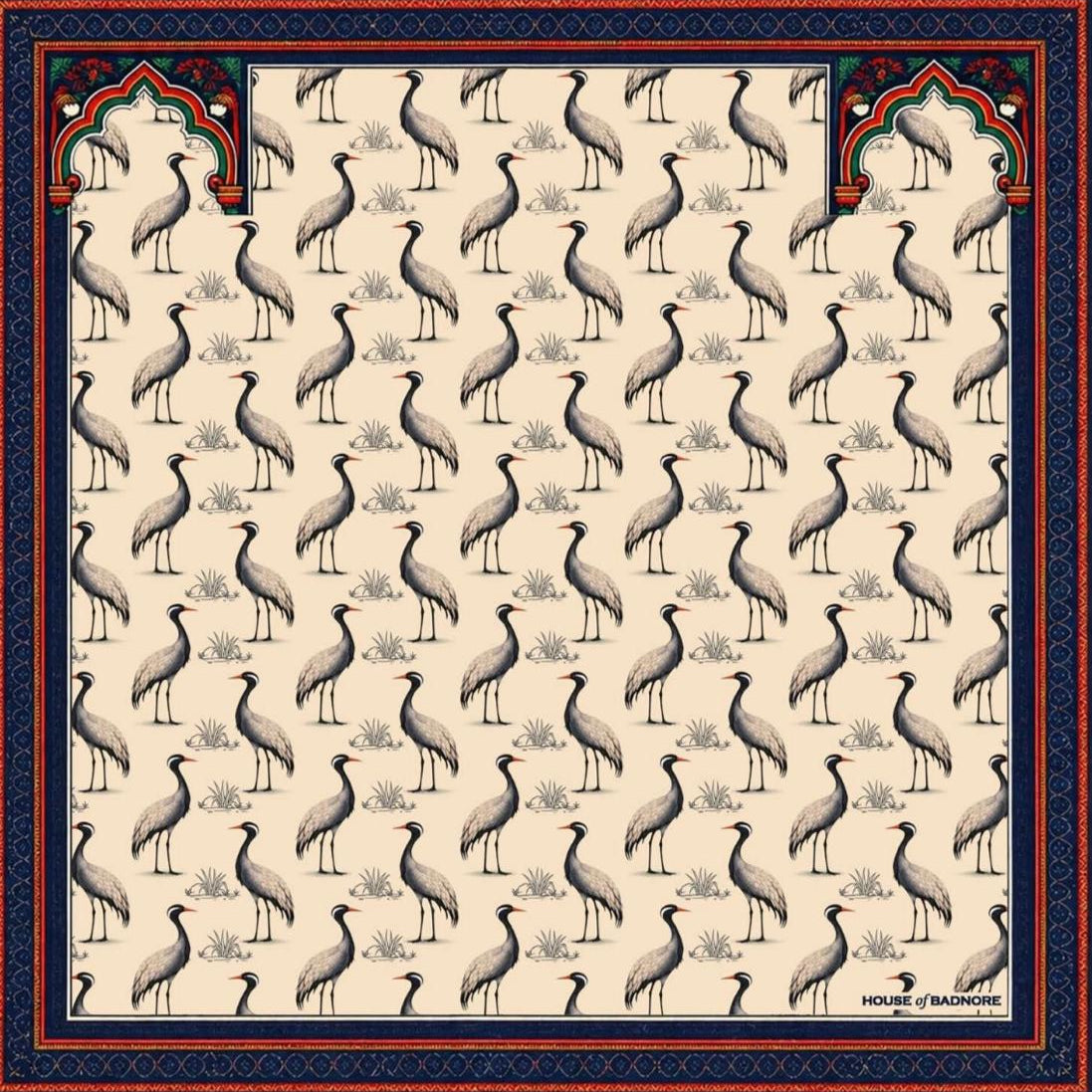 A square scarf featuring a repeating pattern of standing cranes on a warm ivory background, framed by a dark navy blue border with ornate red and green decorative motifs.
