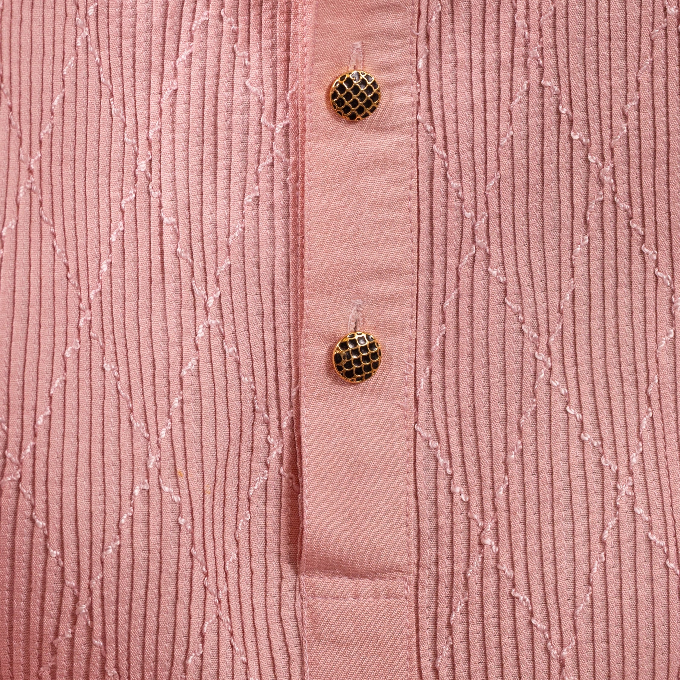 Close-up of a pink textured garment with buttons